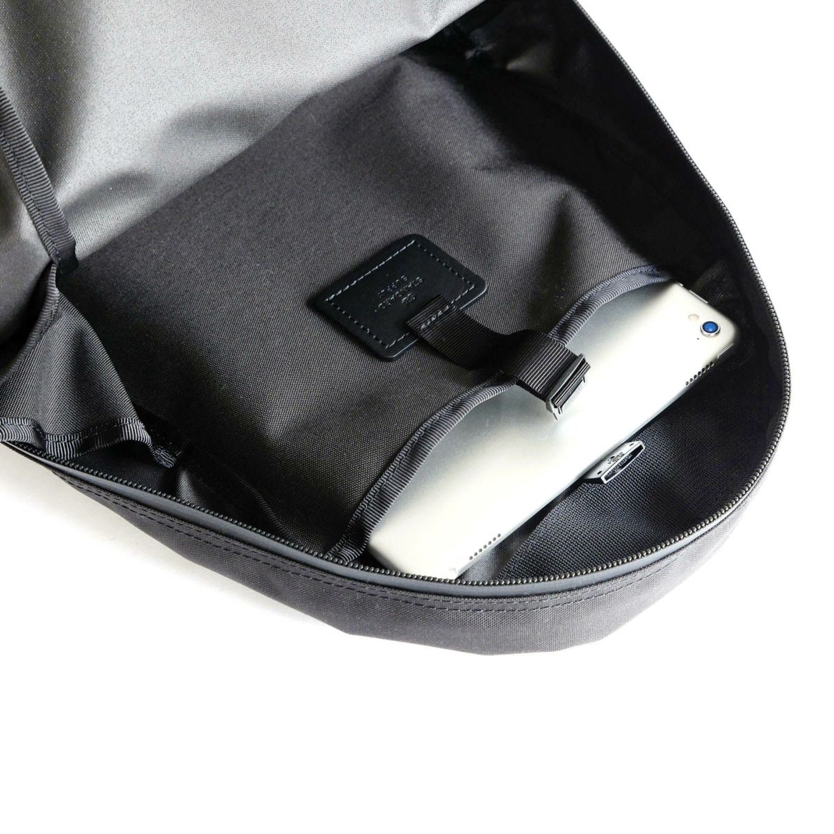 背面側には、プラスチックパーツで留められる</br>スリットポケットがありA4サイズも入ります。